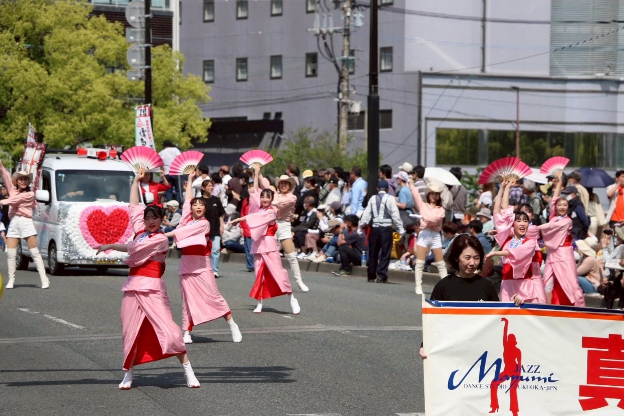 博多どんたくのパレードで扇子を手に踊る出演者たち
