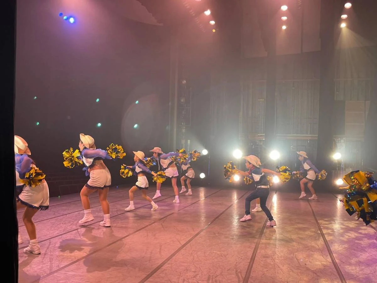 40周年記念公演で帽子とポンポンを使って踊る出演者たち