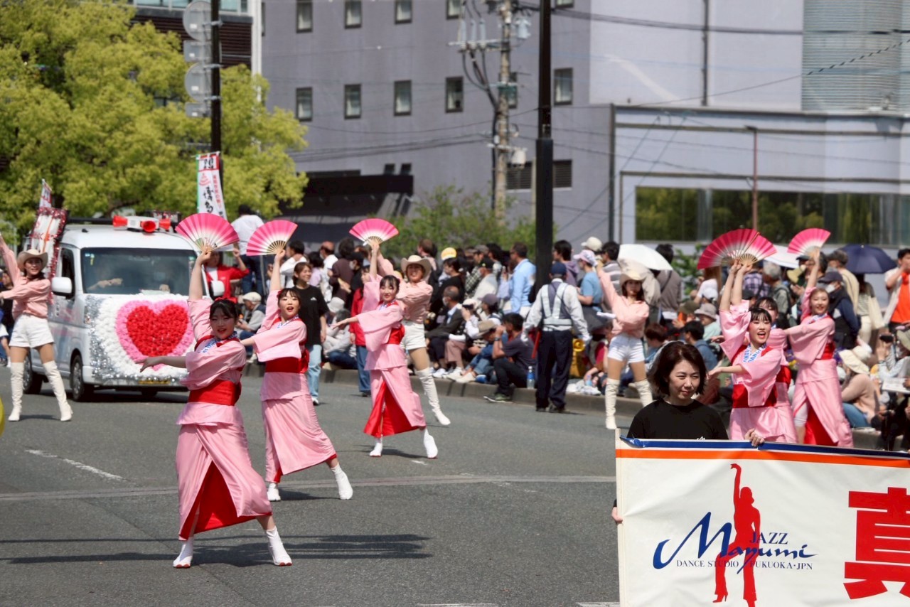 博多どんたくのパレードで扇子を手に踊る出演者たち
