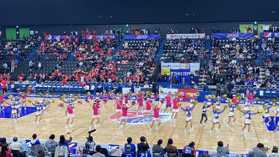 バスケットボール会場のコートで踊る出演者たち