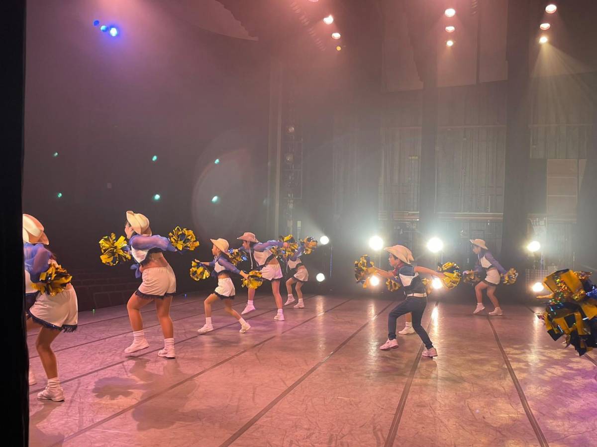 40周年記念公演で帽子とポンポンを使って踊る出演者たち