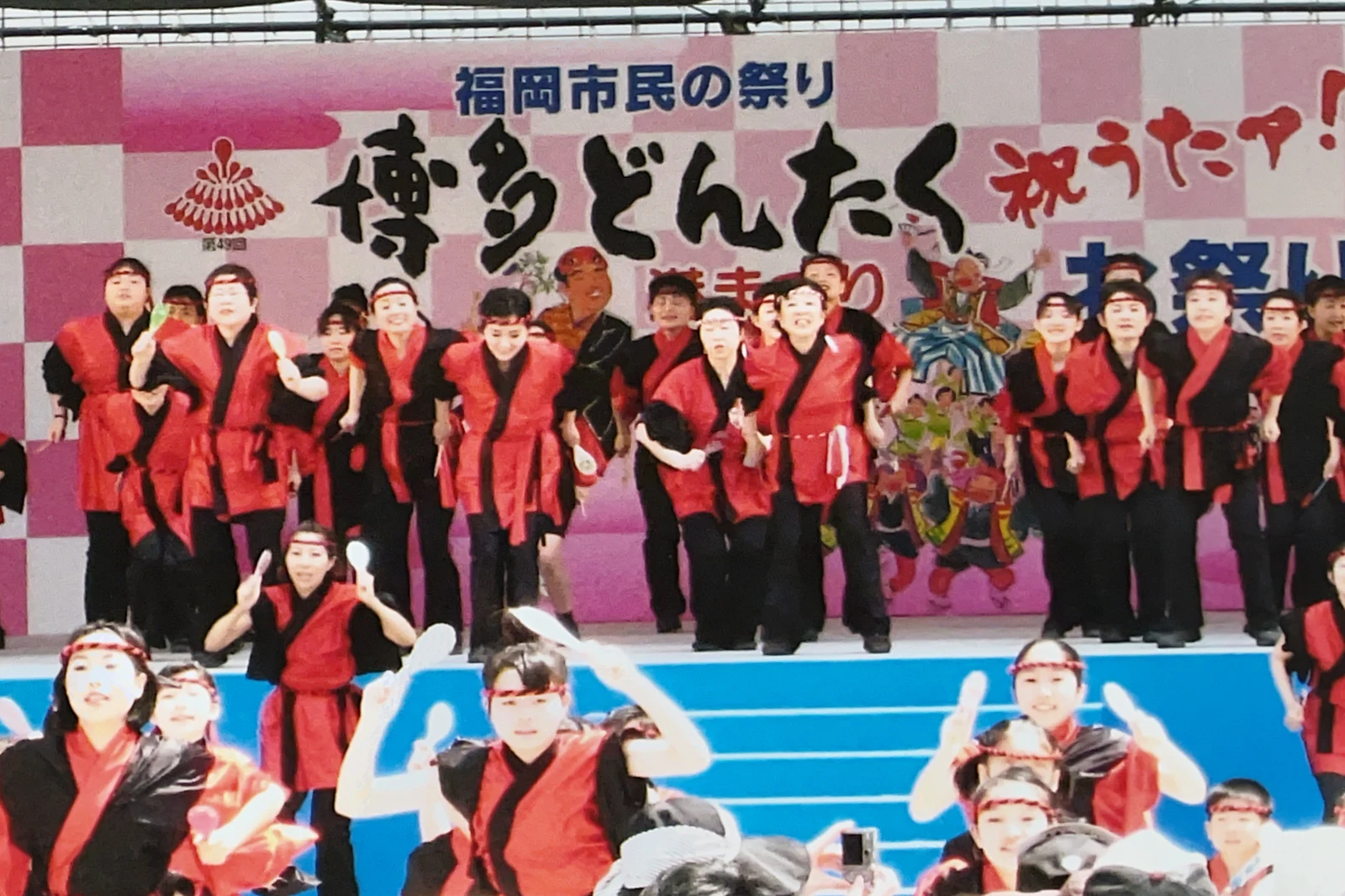 舞台に並ぶ赤い衣装の参加者たち